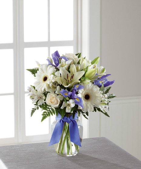 blue and white floral arrangement with gerbera daisies, lilies, roses, and more