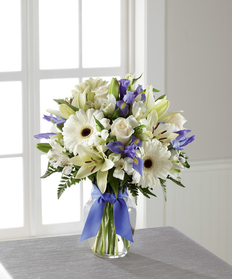 blue and white floral arrangement with gerbera daisies, lilies, roses, and more