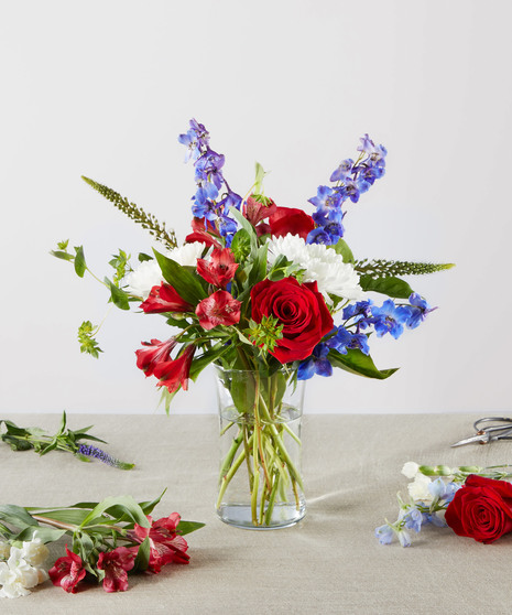 red, white, and blue flowers in tall arrangement