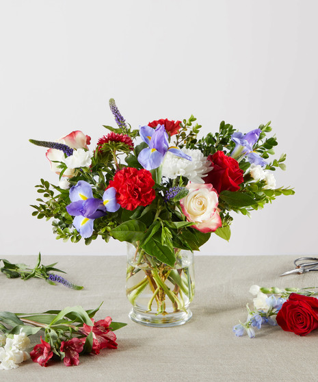 red, white, and blue flowers in tall arrangement