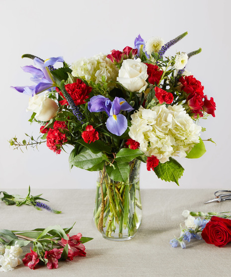 red, white, and blue flowers in tall arrangement